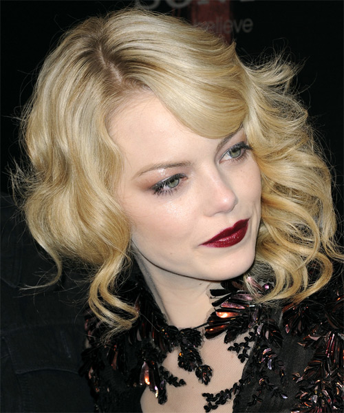 Emma Stone Medium Wavy    Golden Blonde   Hairstyle with Side Swept Bangs  and Light Blonde Highlights - side on view